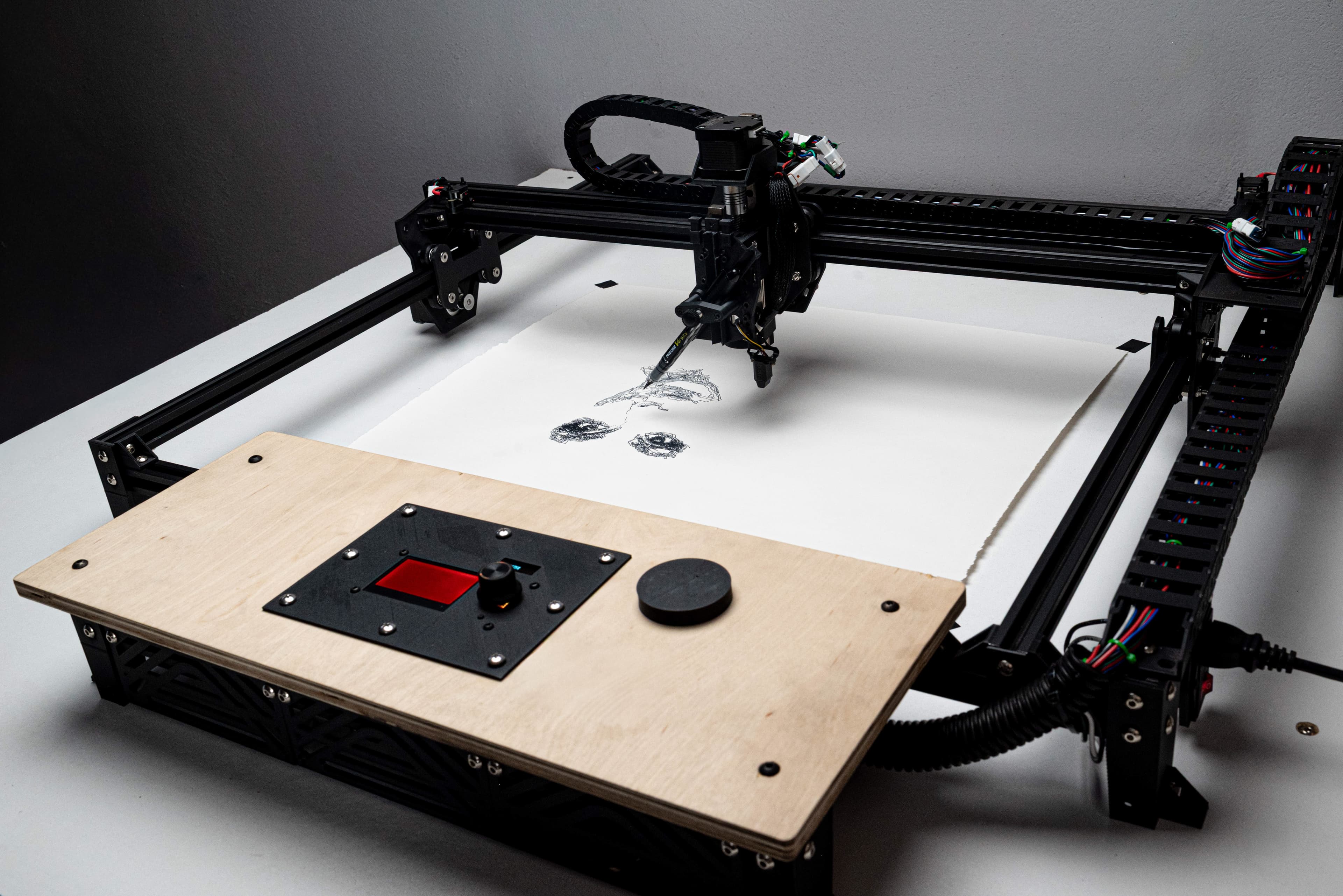 A photo of the Aria Art Plotter with a pen drawing on a sheet beneath its gantry.