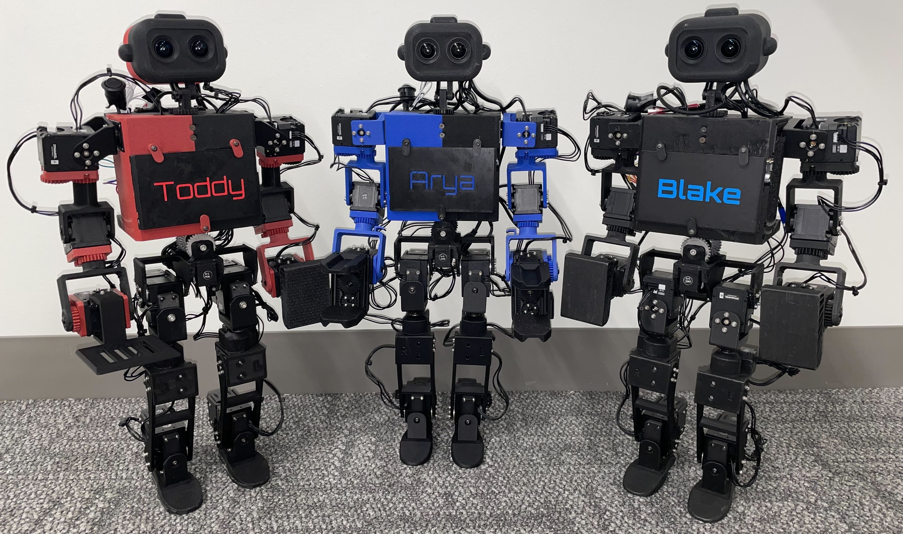 Three ToddlerBot humanoids side by side, with name plates reading Toddy, Arya and Blake