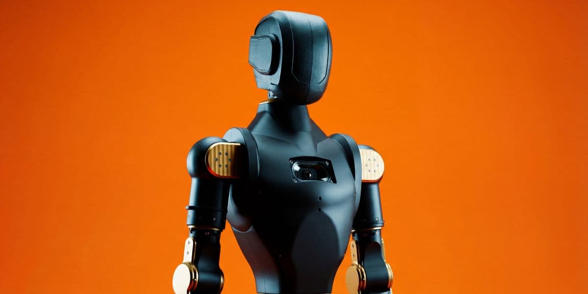 Asimov 1 humanoid robot standing against an orange background.