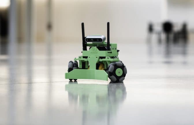 A green Kaya mobile robot with a camera and three wheels